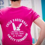 Here, a Child Passenger Safety Technician proudly shows off her T-shirt at a checkup event.